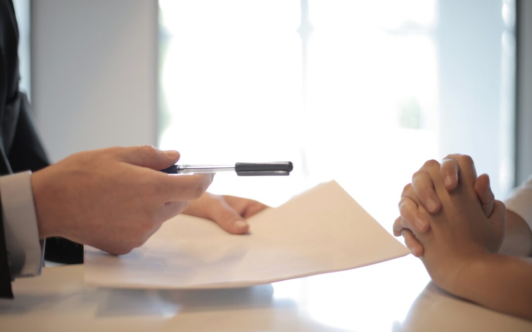 A banker holding out a document to a loan seeker.