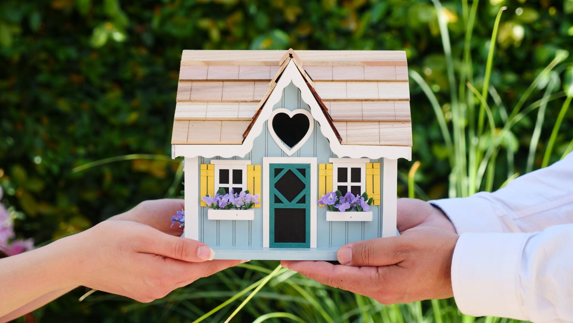 Happy Couples Holding Their Dream House In Their Hands