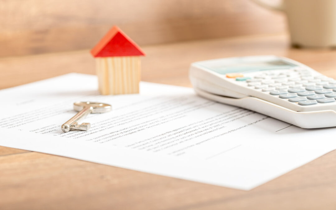 Silver house key lying on a contract for house sale